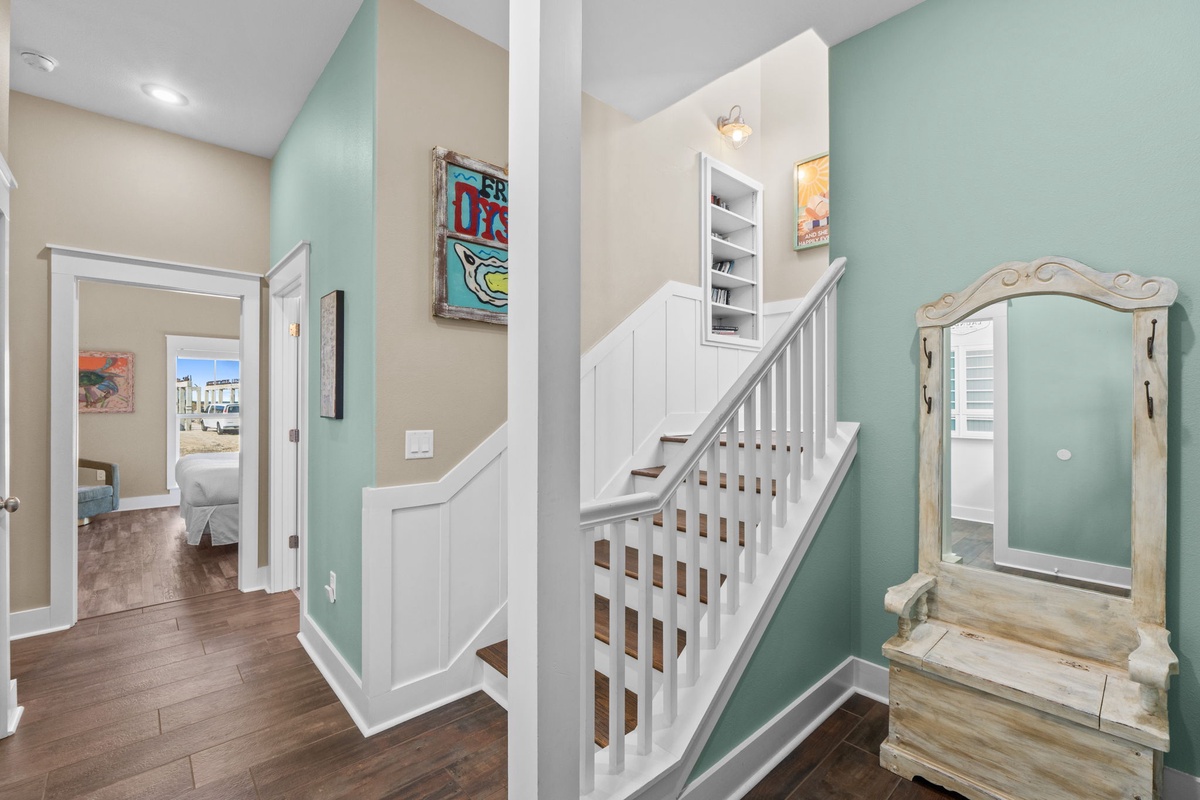 Your welcoming entryway features soothing mint walls, warm hardwood floors, and coastal charm with a rustic mirror.