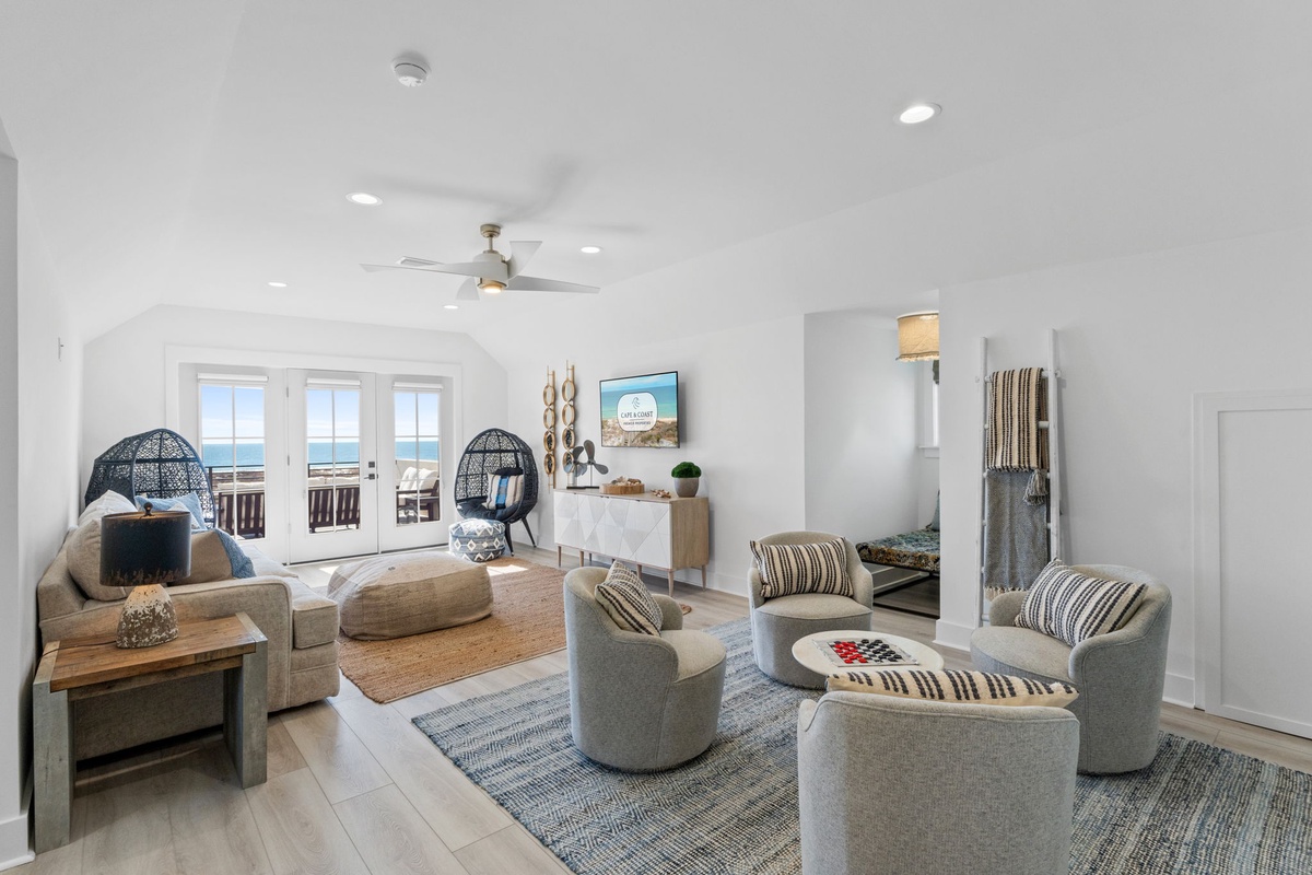 Unwind in your bright, modern living space with stunning ocean views through floor-to-ceiling windows and comfortable coastal-inspired seating.