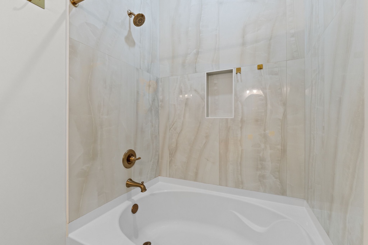 Unwind in your elegant marble bathroom with a soaking tub and rainfall shower, complete with luxurious finishes.