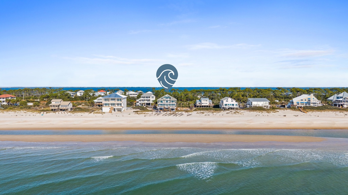 Stunning beachfront location with pristine sandy shores and crystal-clear waters just steps from charming coastal homes.