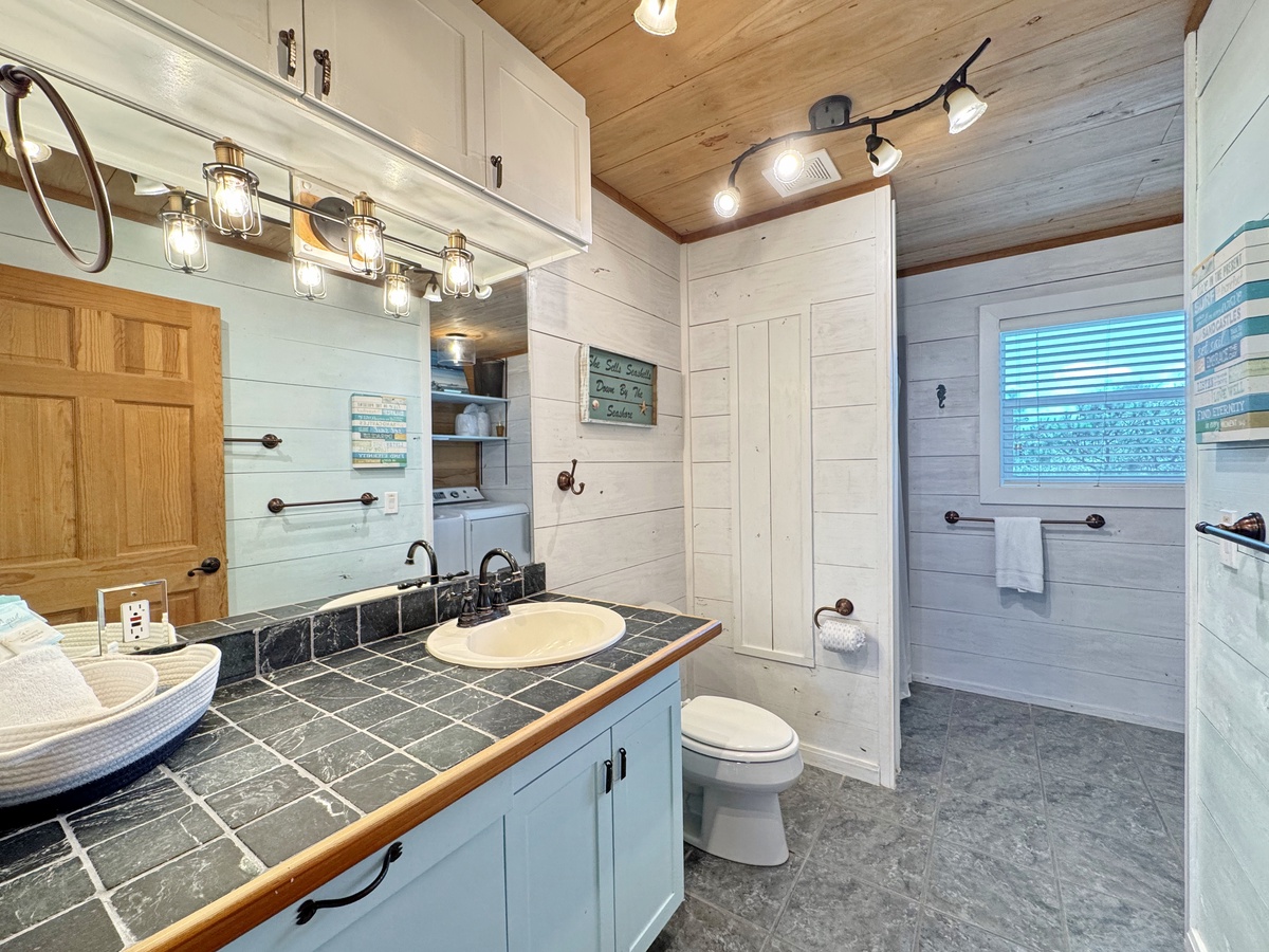 Relax in your spa-like bathroom featuring a beautiful tile vanity, spacious walk-in shower, and coastal charm.
