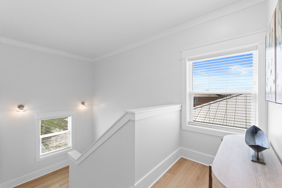 Natural light fills the stairwell, framing views of the surrounding area as you ascend to your private upstairs retreat.