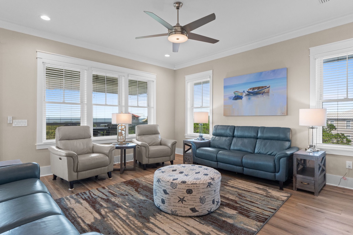 Settle into your bright coastal retreat, where calming neutral tones and soft leather seating invite you to unwind beneath the ceiling fan's gentle breeze after a day at the beach.