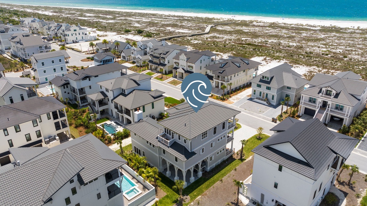 Aerial view of a pristine coastal community nestled between residential streets and white sandy beaches, with the turquoise waters of the Gulf just steps away.