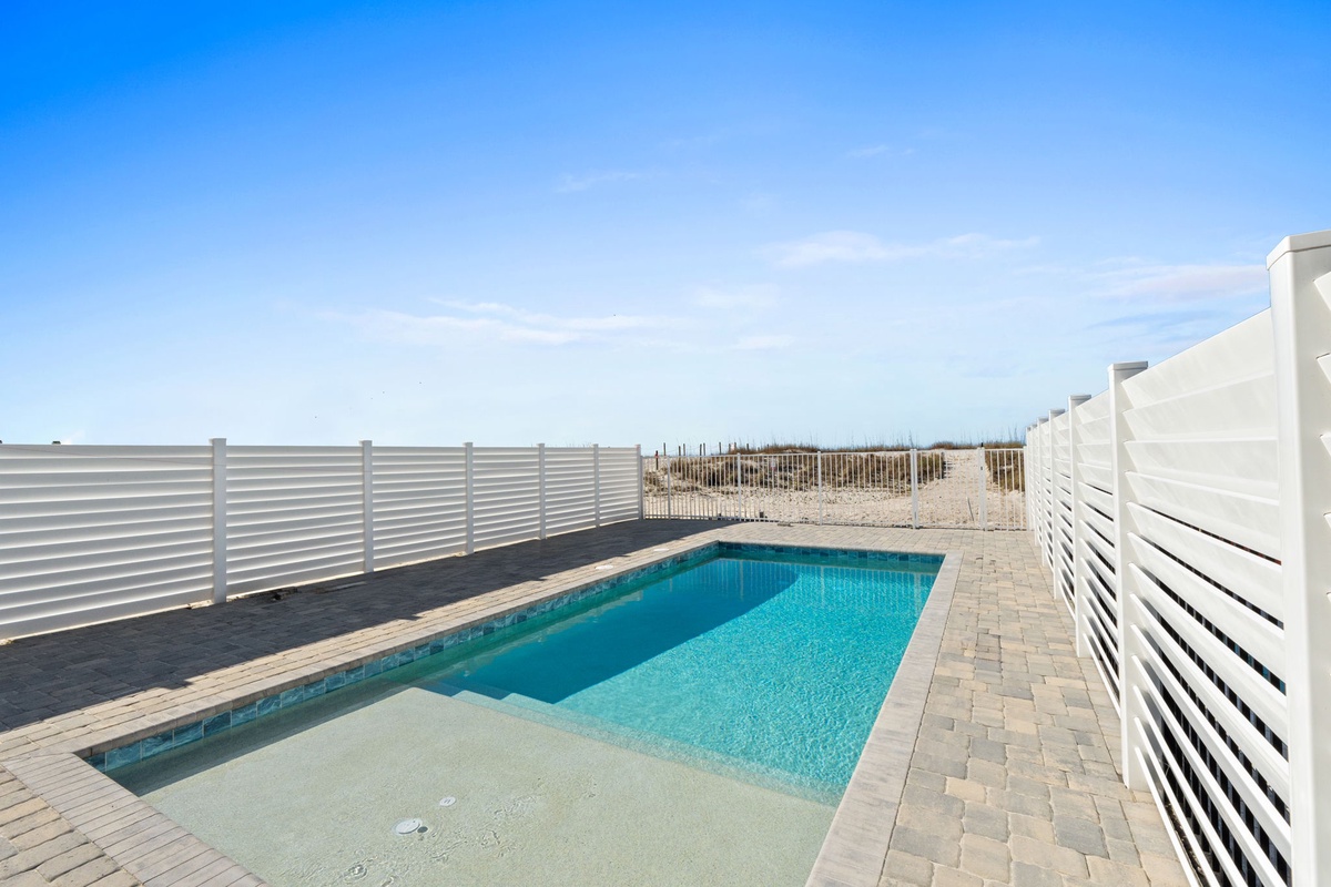 Your private pool oasis awaits, surrounded by modern fencing with crystal-clear water perfect for refreshing swims under the open sky.