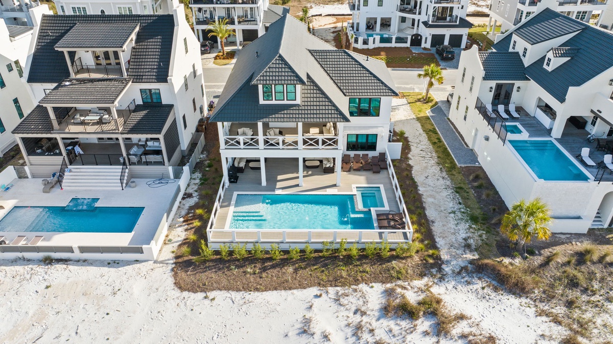 Modern beachfront vacation homes with private pools in an upscale coastal community, featuring contemporary architecture and pristine sandy surroundings.