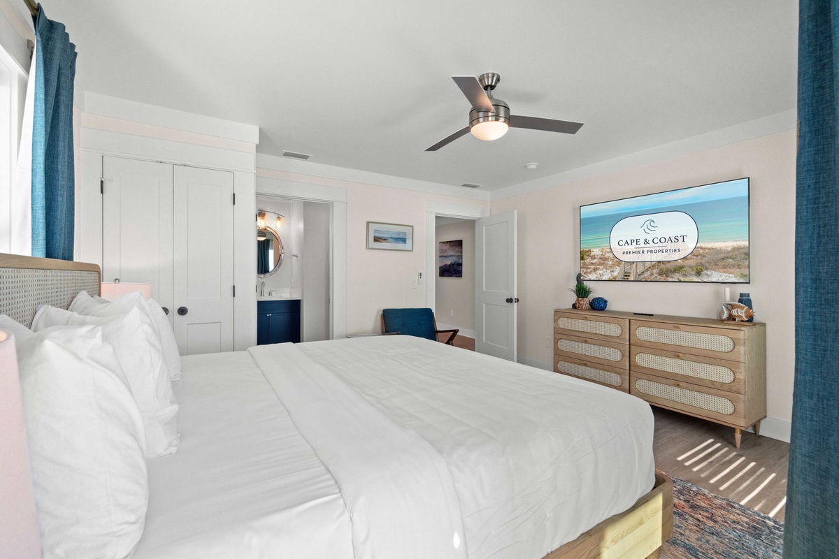Drift off in your coastal sanctuary with crisp linens, gentle ceiling fan breeze, and calming blue accents that echo the nearby shore.