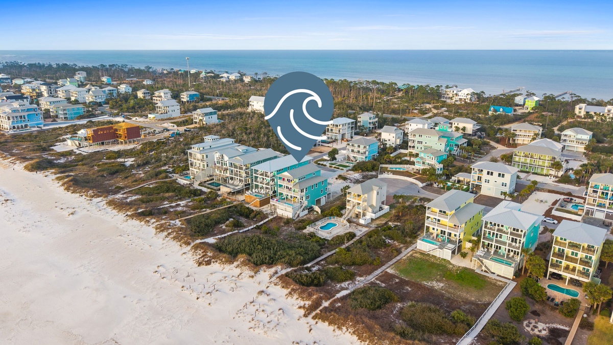 Beachfront community with colorful vacation homes nestled between white sand and Gulf waters. Prime coastal location offers easy beach access.