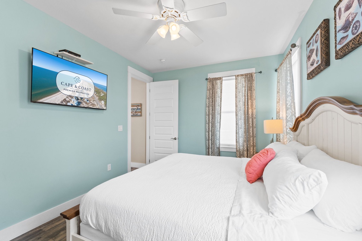Drift into dreams in your coastal-themed bedroom with plush bedding, gentle ceiling fan, and charming nautical touches creating the perfect seaside retreat.