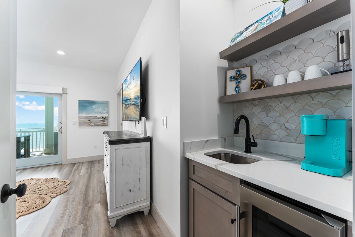 Your stylish kitchenette features modern amenities and ocean-themed touches, perfectly positioned near your sea view balcony for coastal convenience.