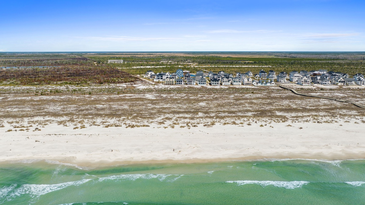Stunning beachfront community with pristine white sand and emerald waters stretching to the horizon.