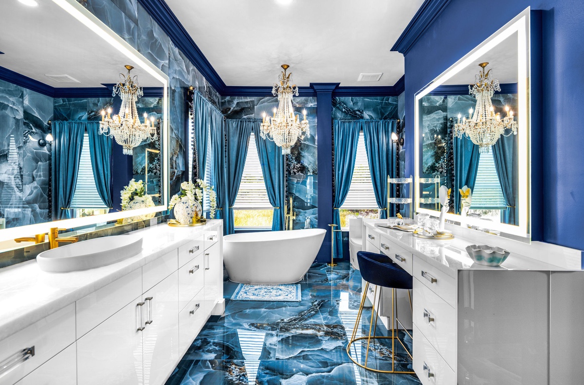 Step into your luxurious spa-like retreat with stunning blue marble accents, elegant chandeliers, and a soaking tub for ultimate relaxation.
