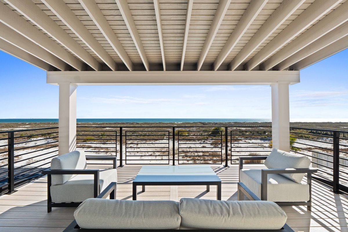 Covered terrace with ocean views and comfortable seating - the perfect spot to unwind with your morning coffee or evening cocktail.