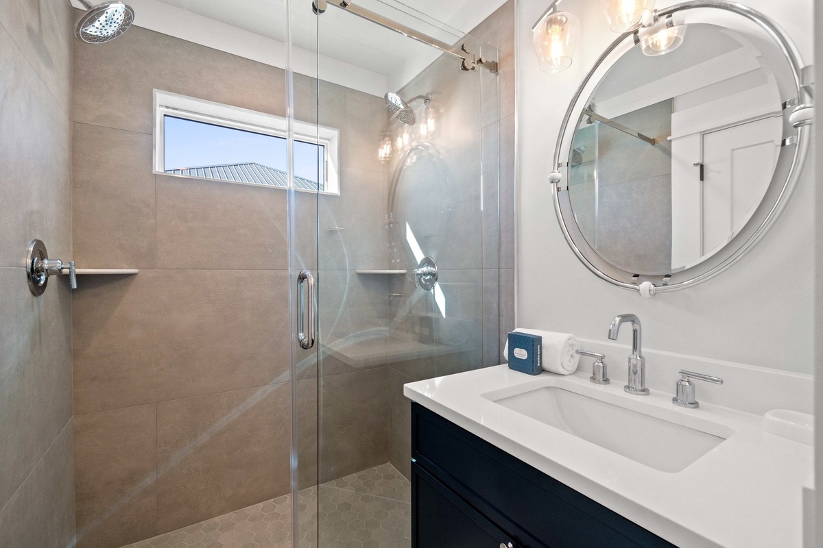 Step into your sleek bathroom featuring a spacious glass shower and elegant vanity where you'll start each day refreshed.