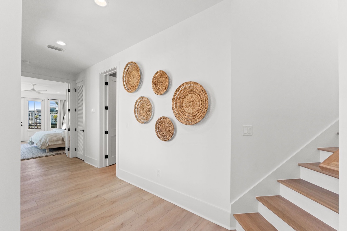 Warm woven art greets you in this bright hallway, where natural light flows from your bedroom into the welcoming space.