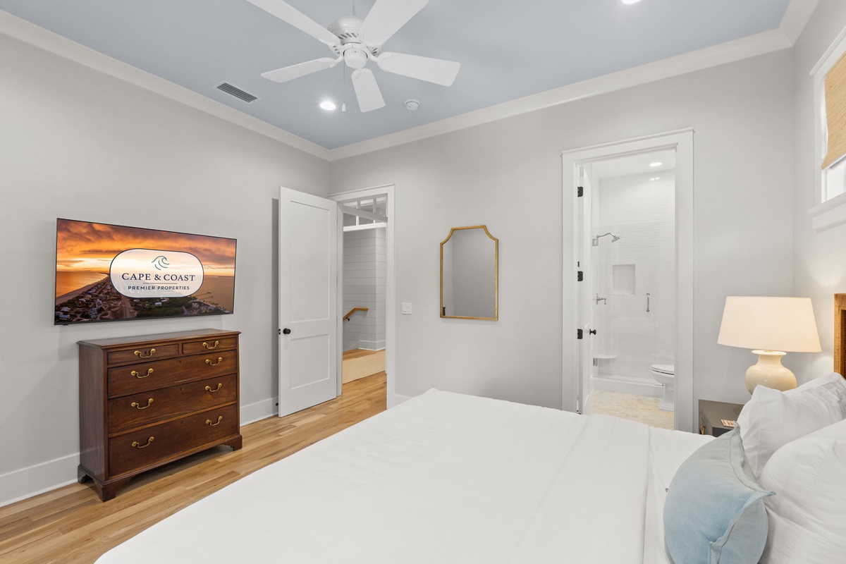 Sink into crisp white linens in this serene bedroom, where soft lighting, elegant furnishings, and an ensuite bathroom create your peaceful retreat after a day exploring the coast.
