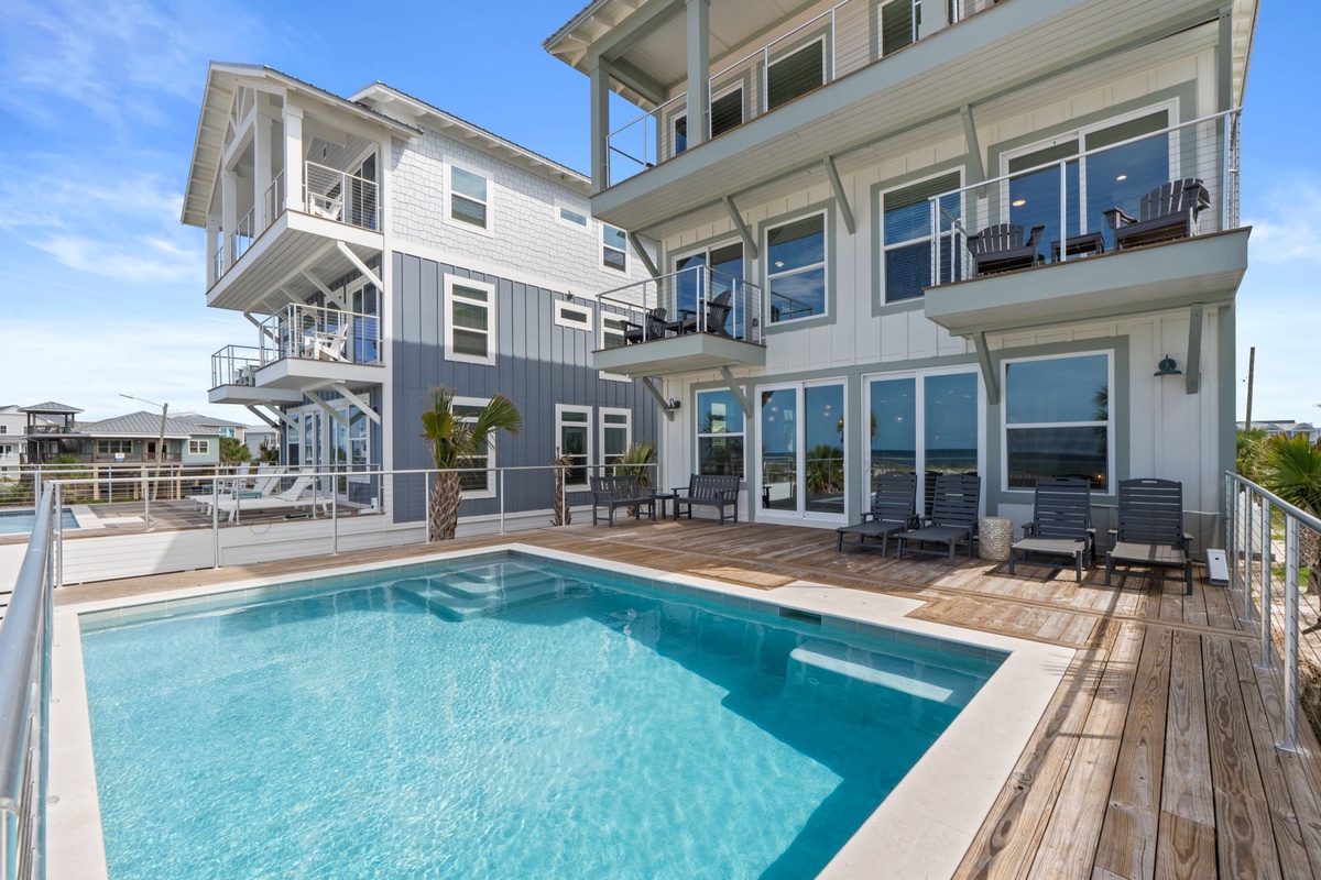 A stunning waterfront property featuring a private pool, spacious balconies, and modern coastal architecture. The sun-soaked deck provides the perfect spot to unwind by the water.