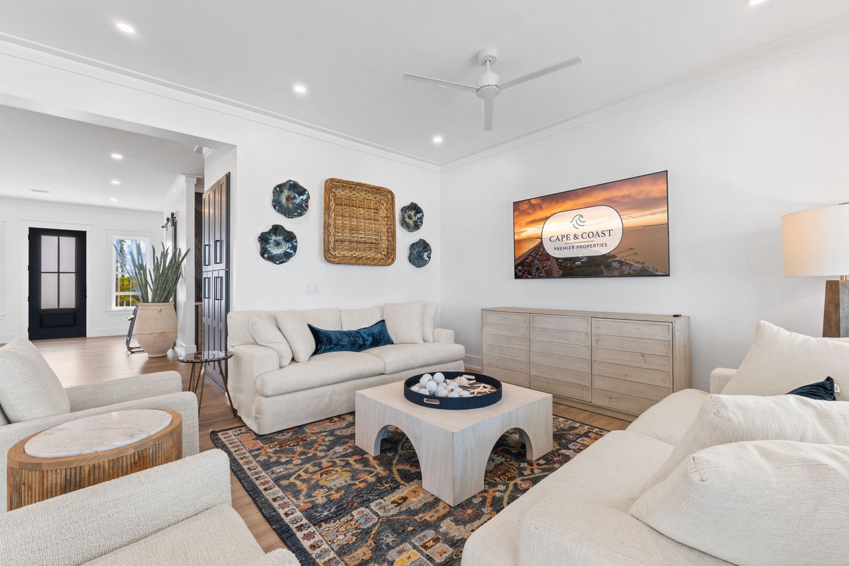 Sink into plush white sofas and unwind in your elegant living space, complete with coastal decor and modern comforts.