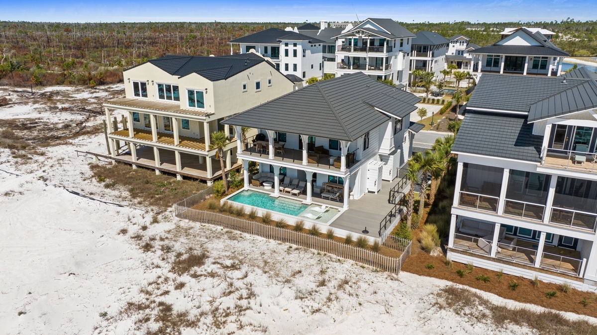 Stunning beachfront property featuring modern coastal architecture with swimming pool and direct beach access.