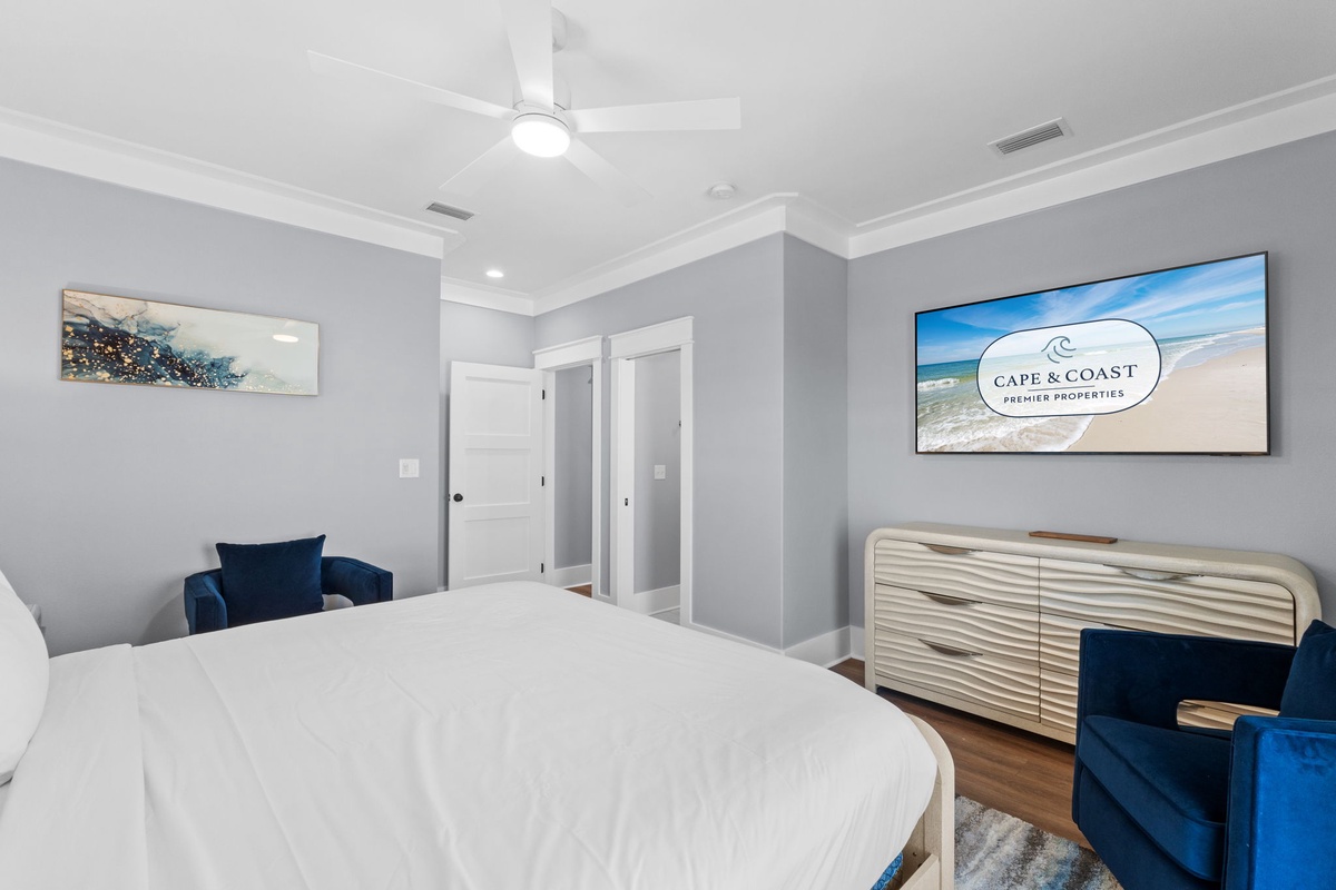 Drift off beneath the gentle ceiling fan in your serene bedroom, where calming coastal tones and plush bedding invite deep relaxation after sun-soaked days.