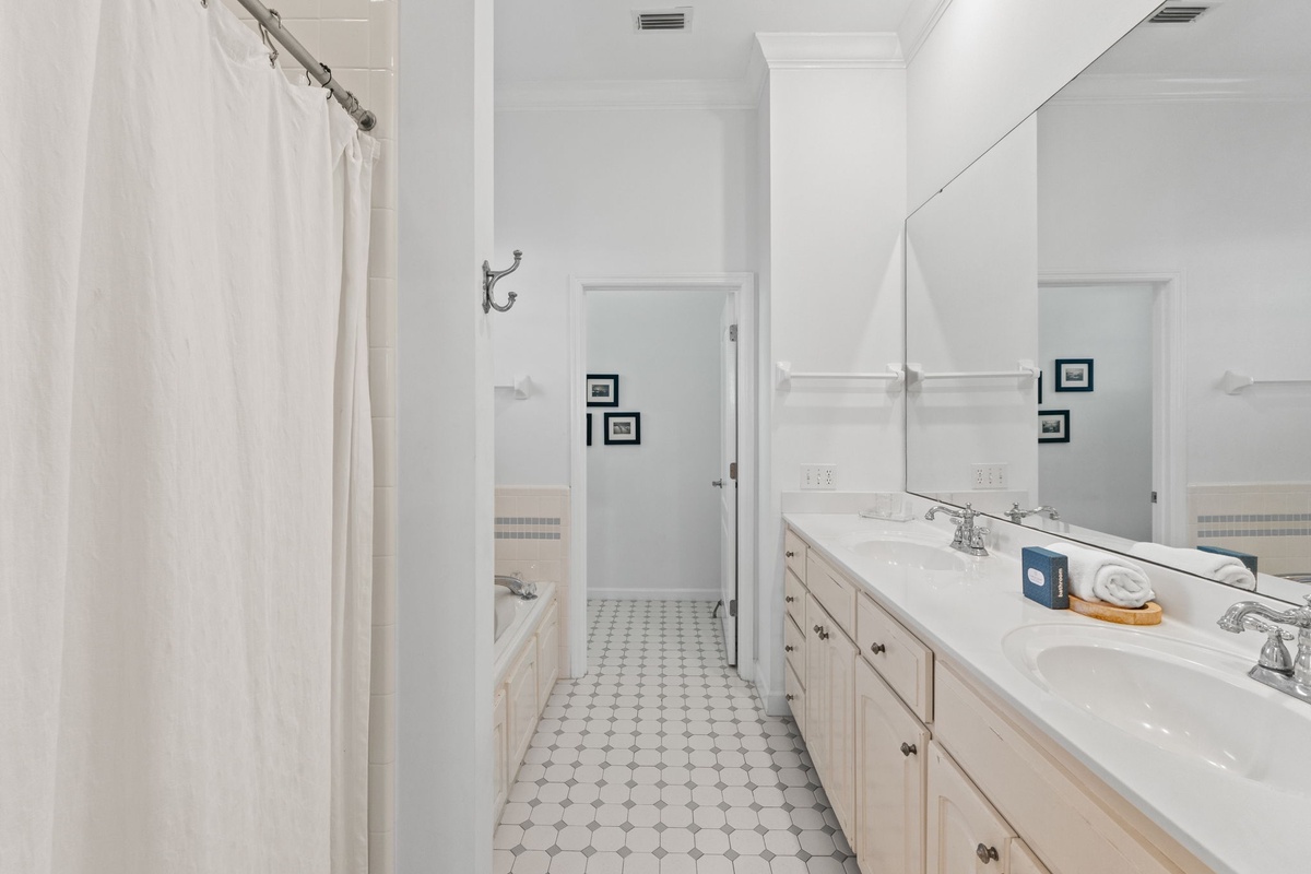 Step into your spacious private bathroom with dual sinks, elegant white countertops, and a relaxing bathtub—perfect for unwinding after your adventures.