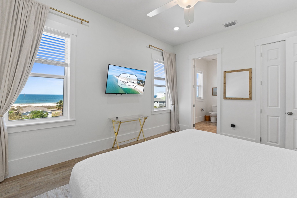 Wake to stunning ocean views from your peaceful bedroom, where crisp white linens and gentle sea breezes create your perfect coastal retreat.