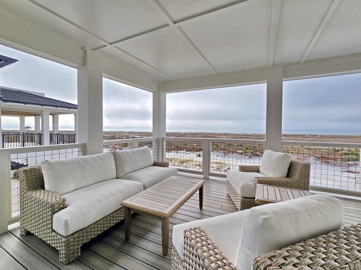 Relax in this covered outdoor lounge where comfortable seating meets panoramic views of the natural landscape stretching endlessly before you.