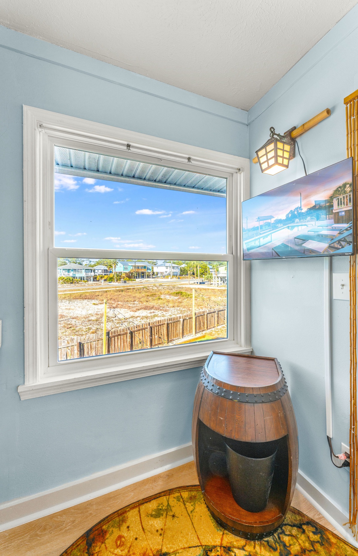 Your nautical-themed nook offers peaceful views of the coastal landscape through bright windows.