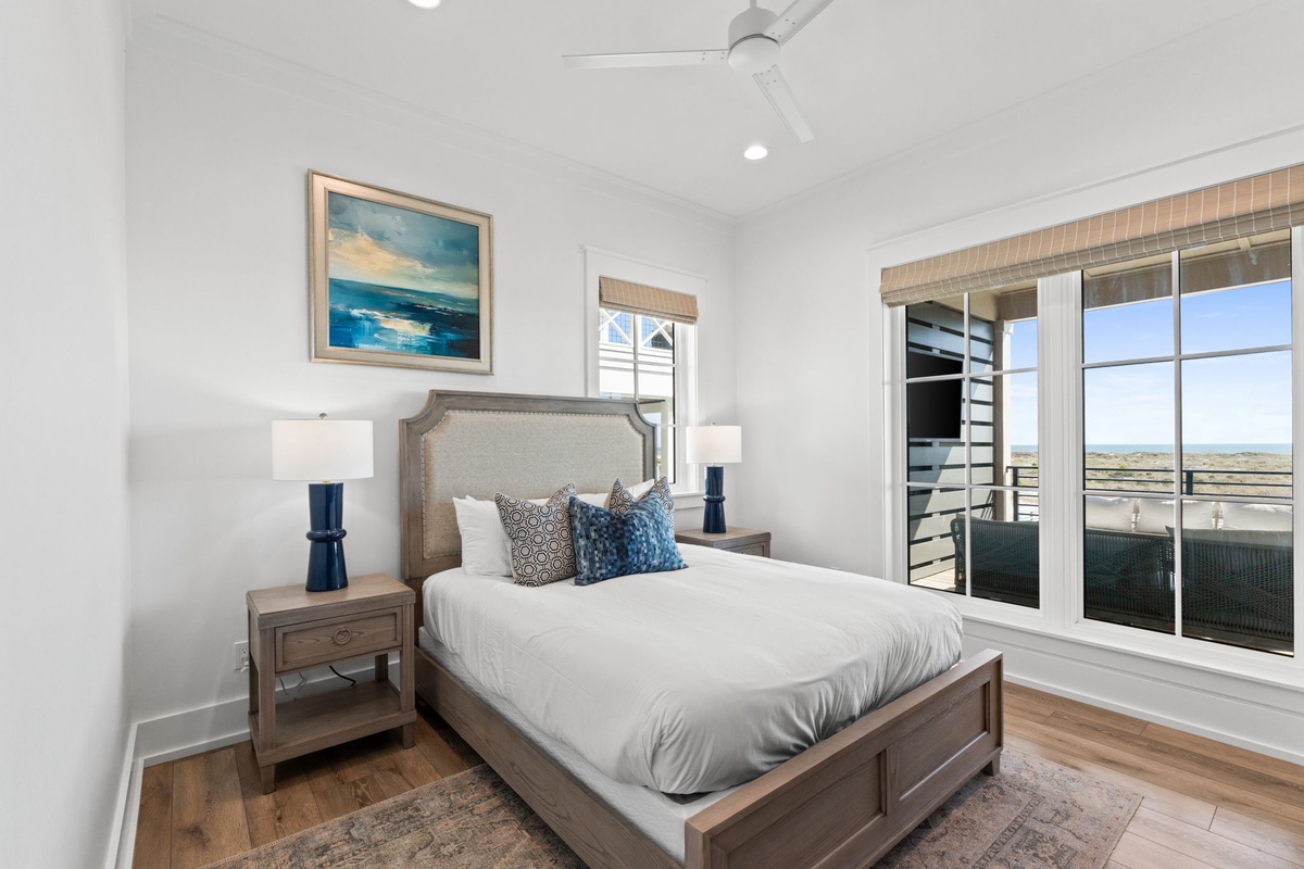 Drift off in your serene bedroom with crisp linens, calming coastal artwork, and peaceful views through expansive windows.