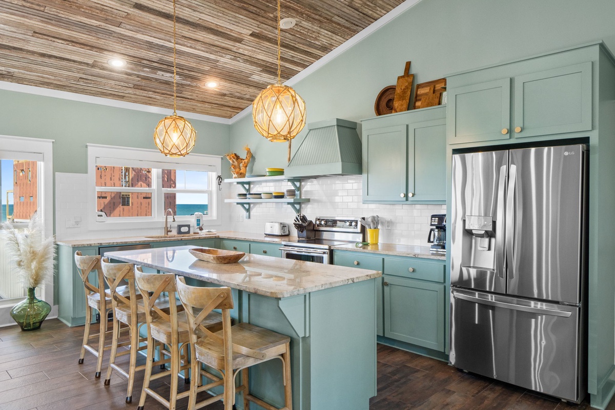 Your spacious kitchen awaits with sage-green cabinets, gleaming granite counters, and a welcoming island perfect for morning coffee or evening conversations.