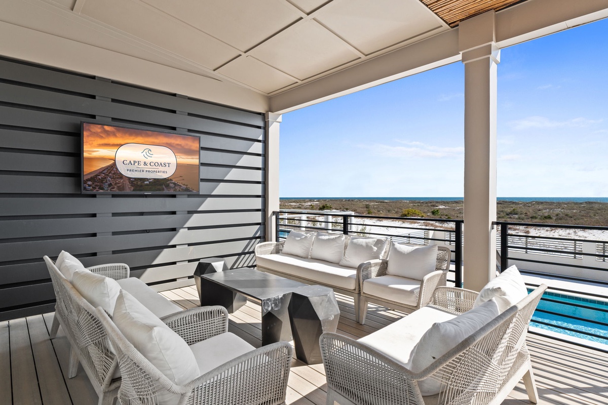 Unwind in your private covered terrace with stunning coastal views, where comfortable seating awaits your morning coffee moments.