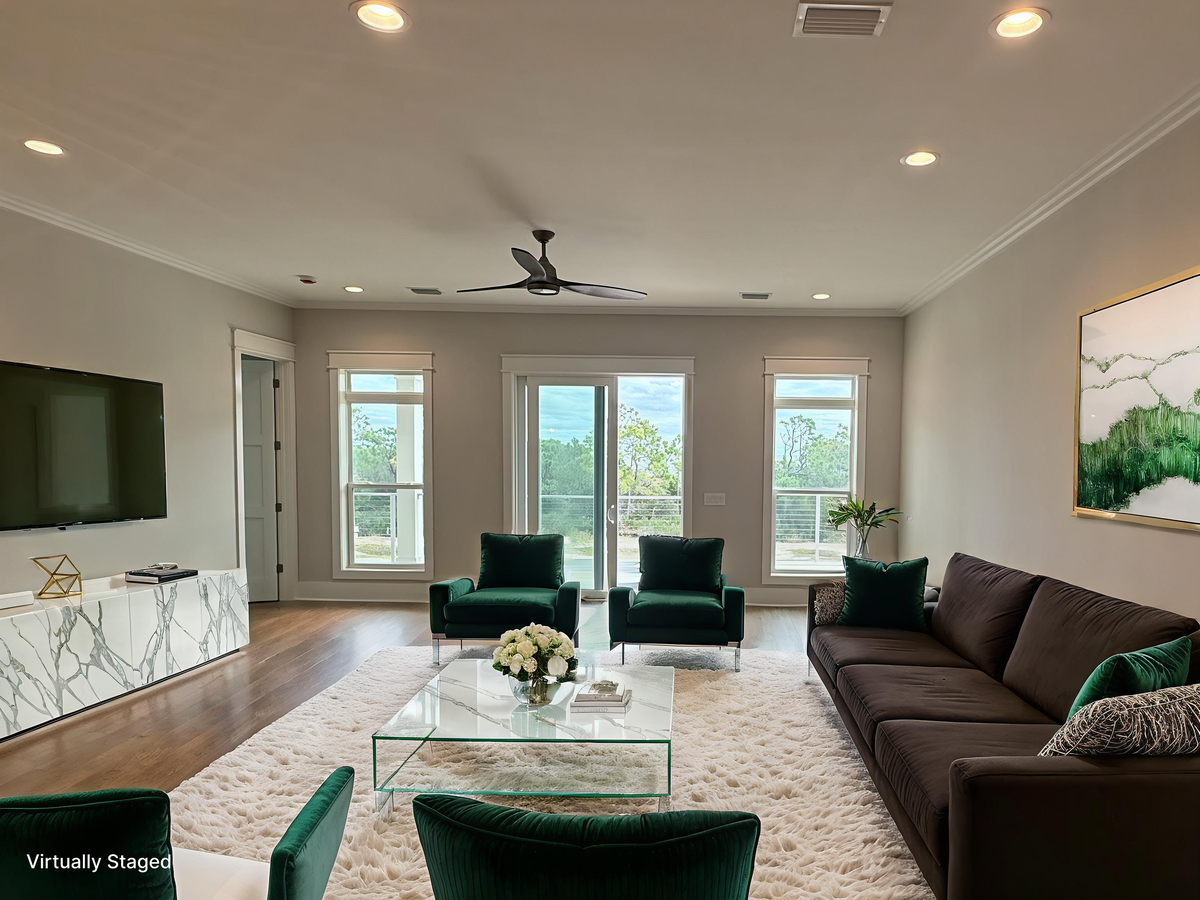 Relax in your elegant living space with plush emerald seating and stunning natural views through floor-to-ceiling windows.