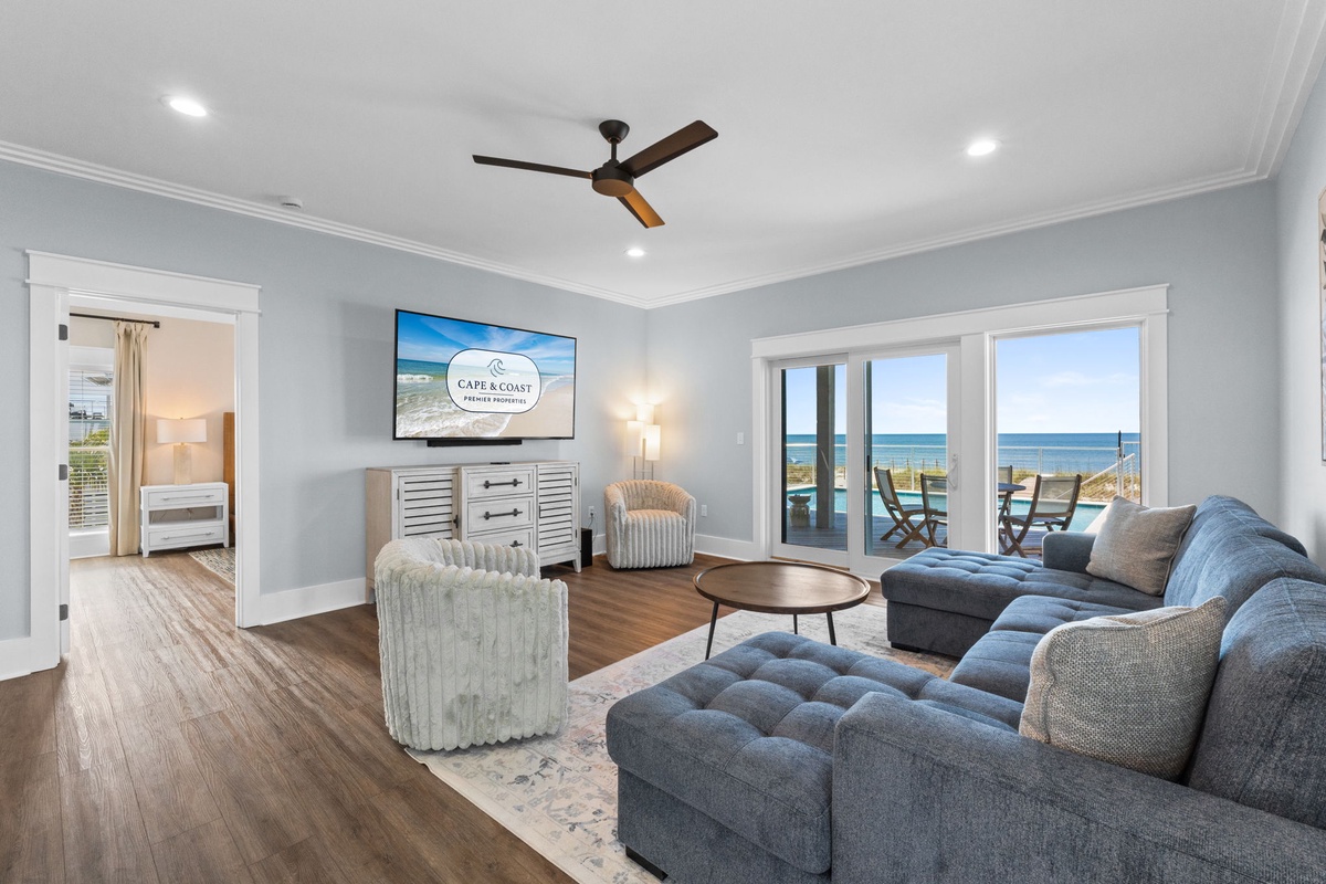 Sink into the plush sofa and soak in the stunning ocean views through the sliding glass doors. Your perfect coastal retreat awaits with soft lighting, stylish decor, and a gentle sea breeze.