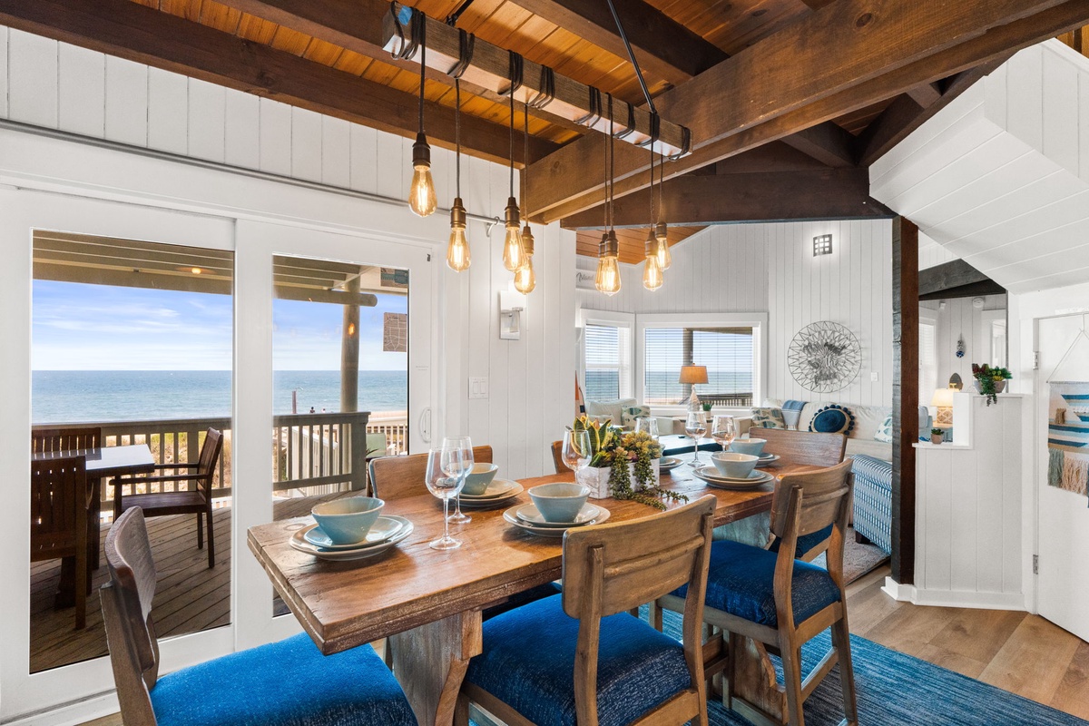 Step into this stunning beachfront dining space with sweeping ocean views just beyond your deck. Rustic wood beams, warm pendant lighting, and coastal-inspired décor create the perfect setting for memorable meals with loved ones.