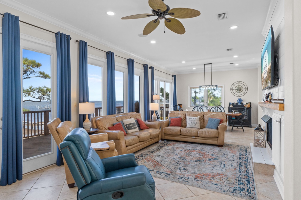 Relax in your spacious living room with leather seating, tropical ceiling fan, and fireplace, all while enjoying stunning ocean views through expansive windows.