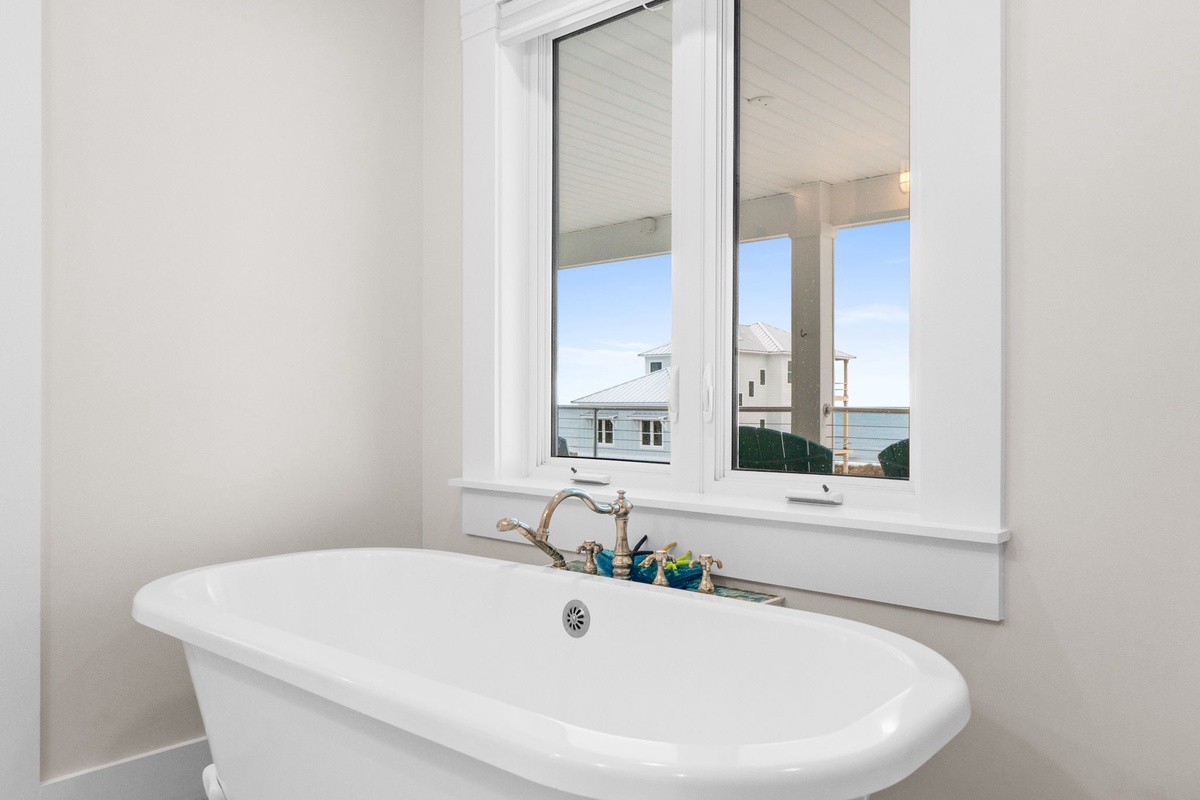 Unwind in your elegant freestanding tub with peaceful neighborhood views streaming through bright windows.