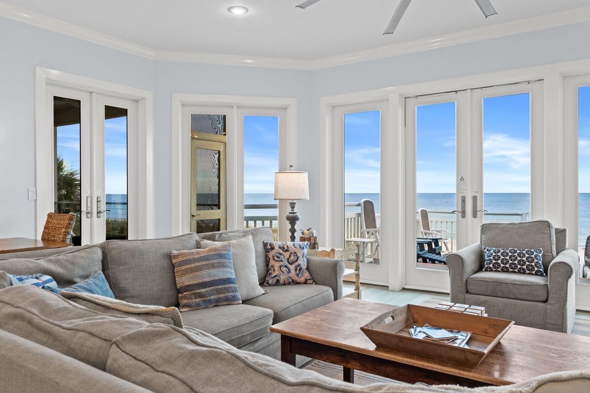 Sink into plush sofas while gazing at endless ocean views through floor-to-ceiling windows that frame your coastal paradise perfectly.