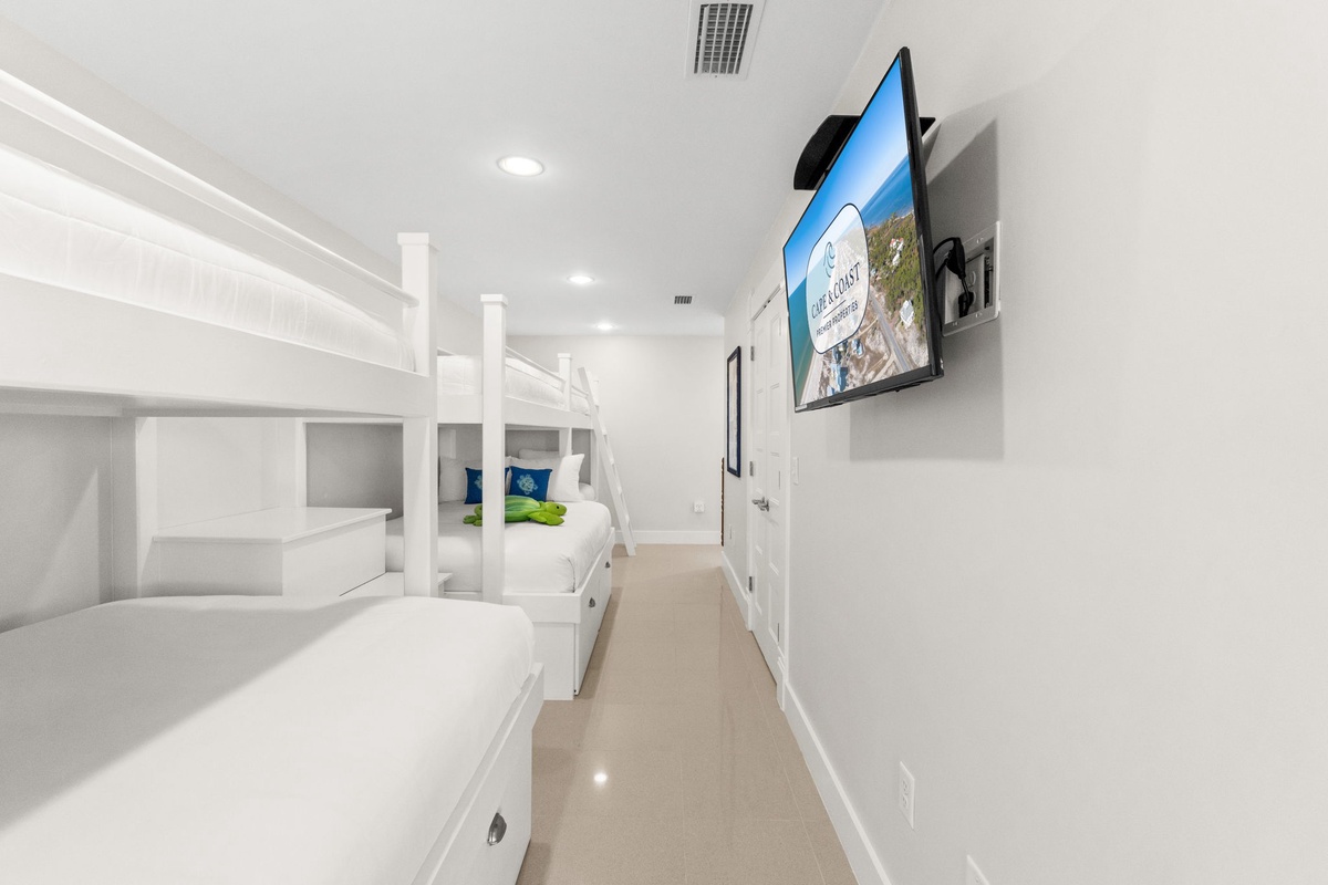 Rest easy in your private bunk room with crisp white linens and entertainment ready for movie nights after adventure-filled days.