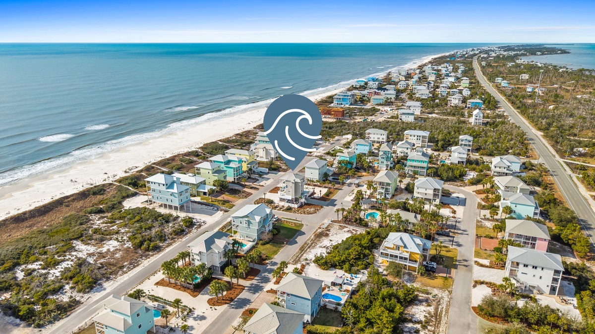 Aerial view of coastal vacation rental community with pristine beaches, private pools, and oceanfront properties nestled among natural vegetation.