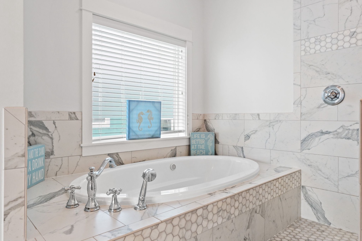 Sink into your private marble sanctuary, where coastal charm meets luxury with honeycomb accents and beach-themed touches for pure relaxation.
