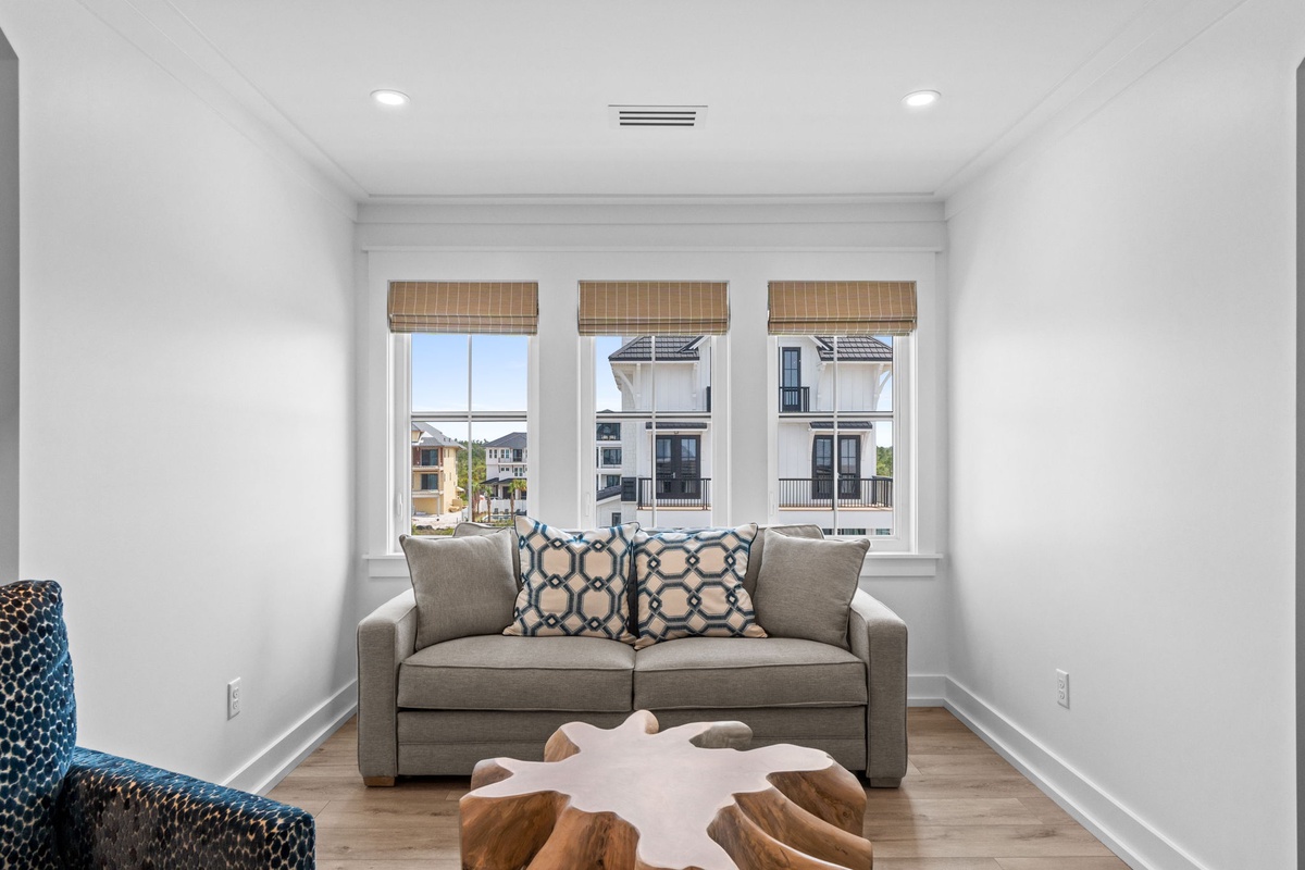 Settle into your private living room where natural light floods through triple windows, highlighting sleek air conditioning, warm wood floors, and a cozy seating area that's all yours.