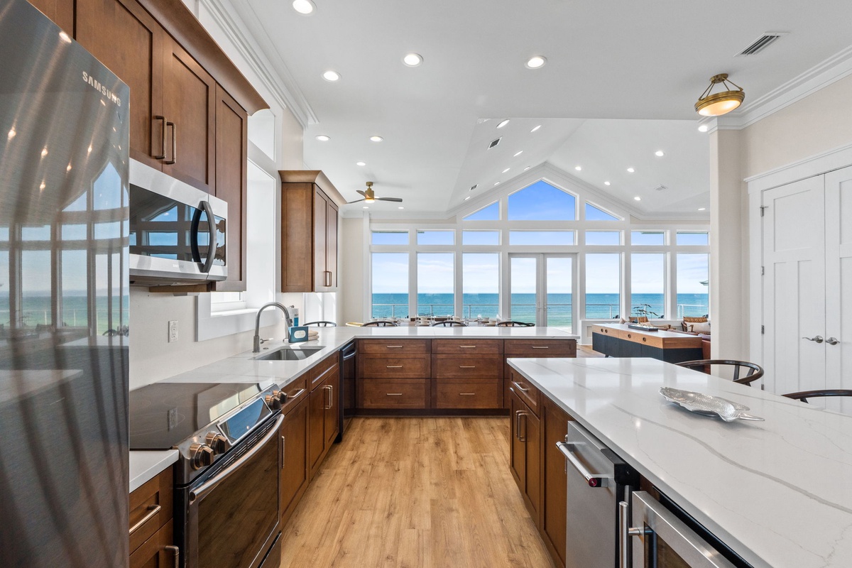 Your gourmet kitchen opens to stunning ocean views through floor-to-ceiling windows, where cooking becomes pure joy with endless blue horizons as your backdrop.