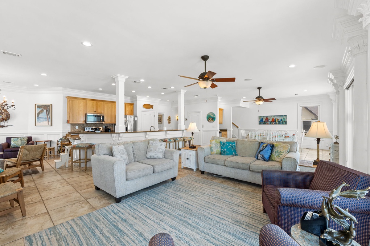 Relax in this bright, open living space where coastal charm meets comfort. Sink into plush sofas, enjoy the breeze from ceiling fans, and gather with loved ones in a home designed for memorable vacation moments.