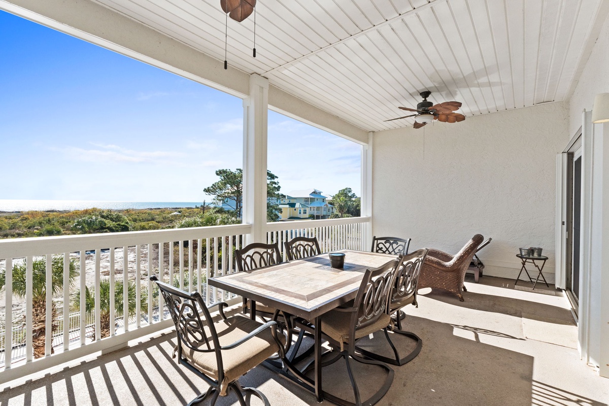Your covered dining terrace features ceiling fans and comfortable seating where you can enjoy meals while taking in coastal views.