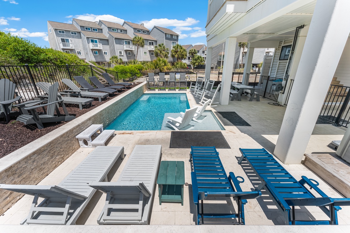 Dive into your private pool paradise with multiple loungers, covered dining, and vibrant blue waters beckoning under sunny skies.