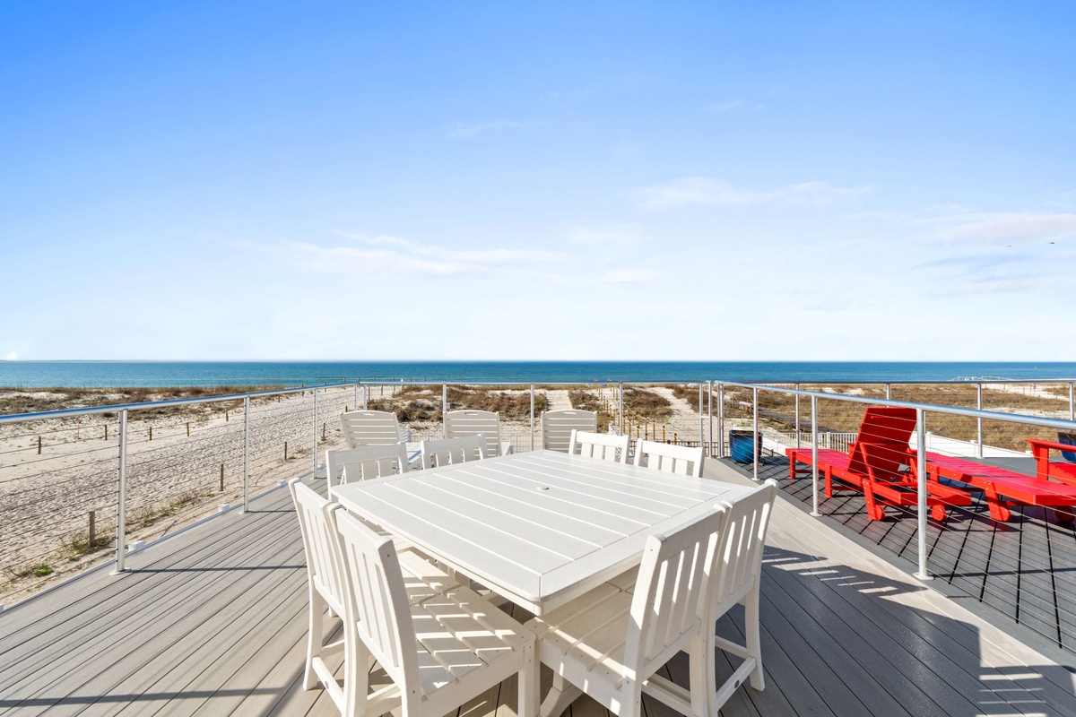 Oceanfront dining terrace with beachside seating directly overlooking pristine coastline and endless azure waters.