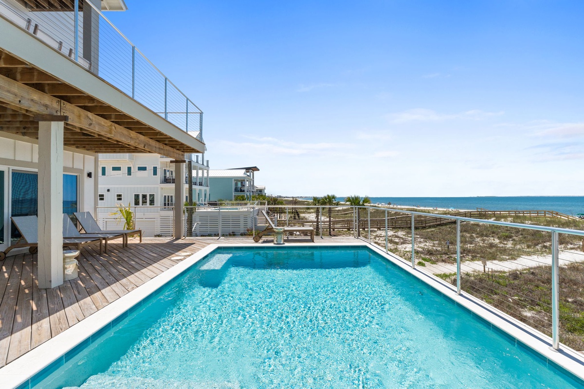 A stunning beachfront property featuring a private pool deck where turquoise waters meet white sandy beaches and endless ocean horizons.