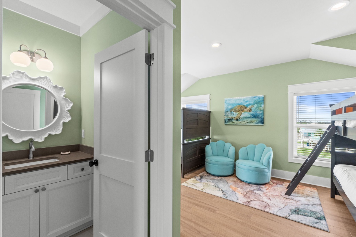 Your coastal retreat features calming mint walls, playful turquoise seating, and a whimsical sea turtle painting—perfect for unwinding after beach adventures with your family.