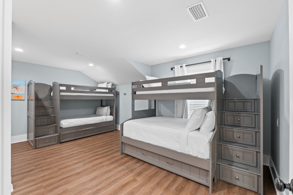 Two bunk bed sets with plush white linens create a spacious shared sleeping area, perfect for your family or group gatherings in comfort.