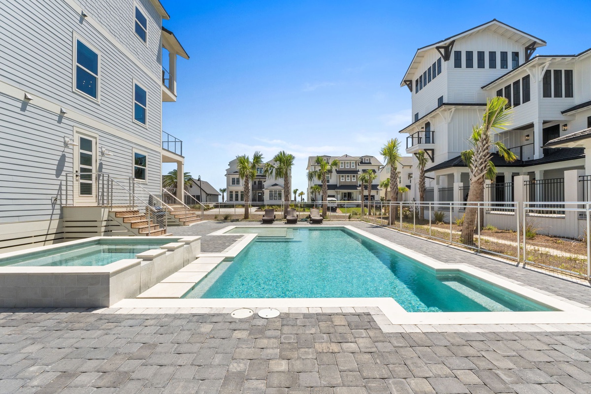 A sparkling pool and spa await in this coastal community, surrounded by palm trees and beach-style homes with balconies, offering a perfect spot to unwind under the Florida sun.